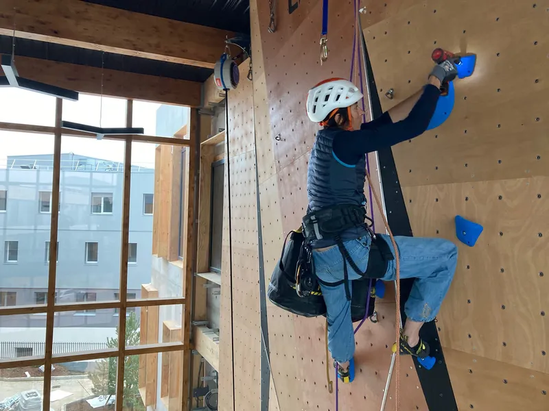 Chloé encordée sur un mur d’escalade en bois